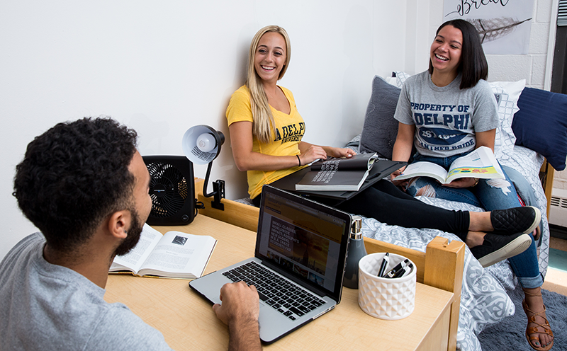 Adelphi students talking and studying in a dorm room