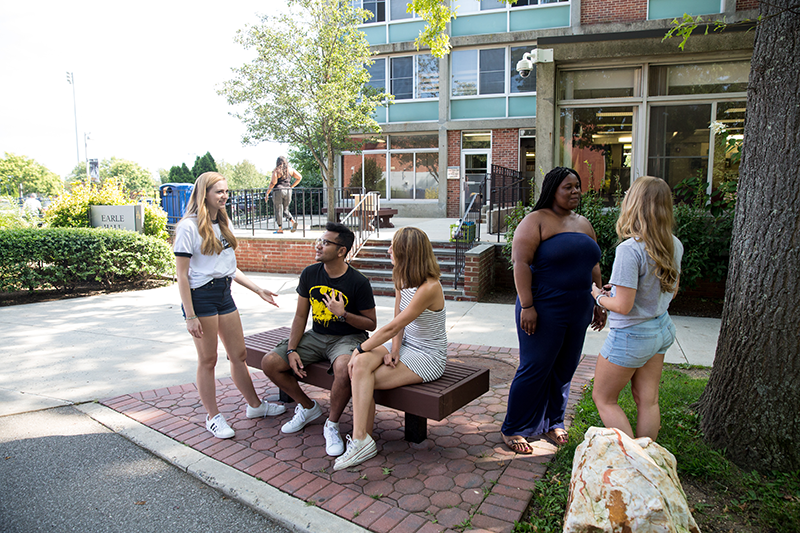 Adelphi students socialize in front of Earle Hall
