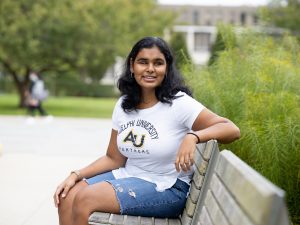 Jessica Karim sitting on a bench on Adelphi University's campus