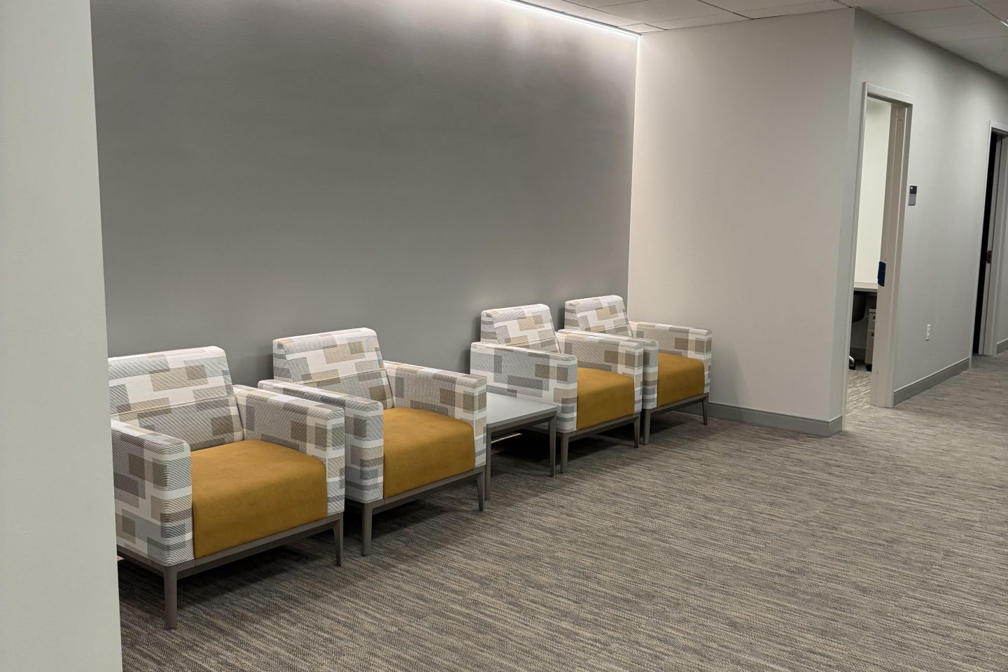 Four comfortable chairs in a hallway.