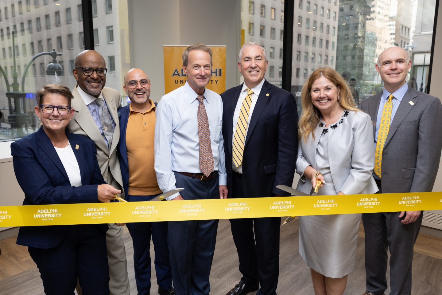 Executive Director Jennifer Lancaster (left), Interim Chair Bill Fuessler and President Balboni (center) celebrated the ribbon cutting with members of the executive leadership team and friends of the university.