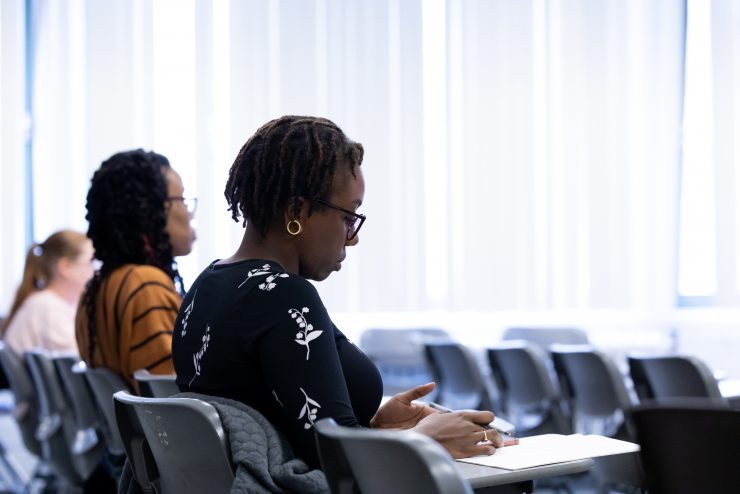 Adelphi students in the classroom - writing notes and focused