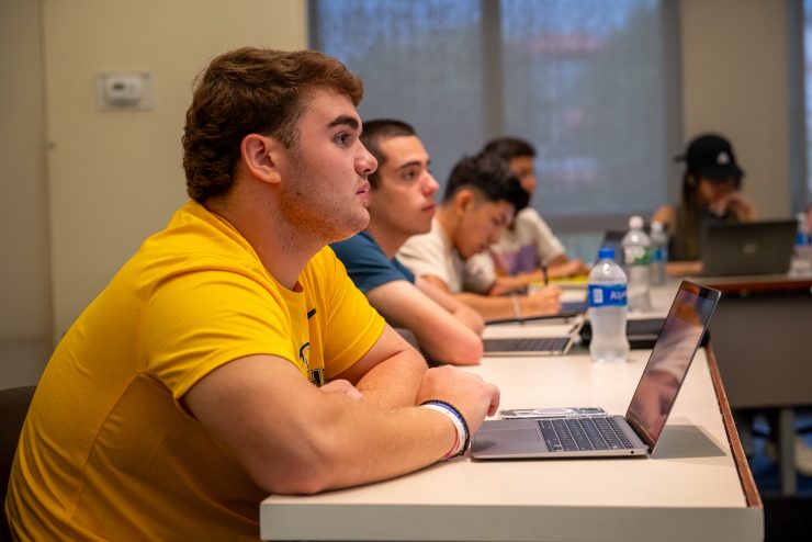 Students listening in class and taking notes - Economics Class Prof. Ryoo