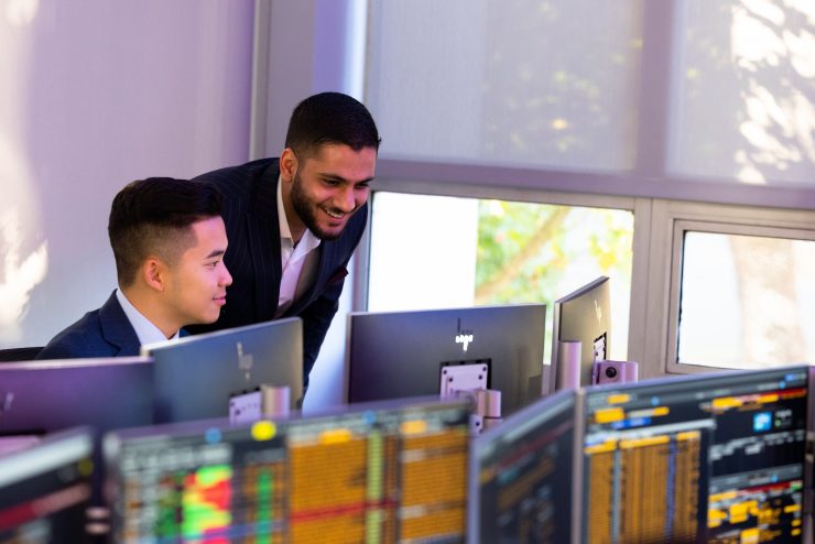 Business students working in the Trading Room on Bloomberg terminals