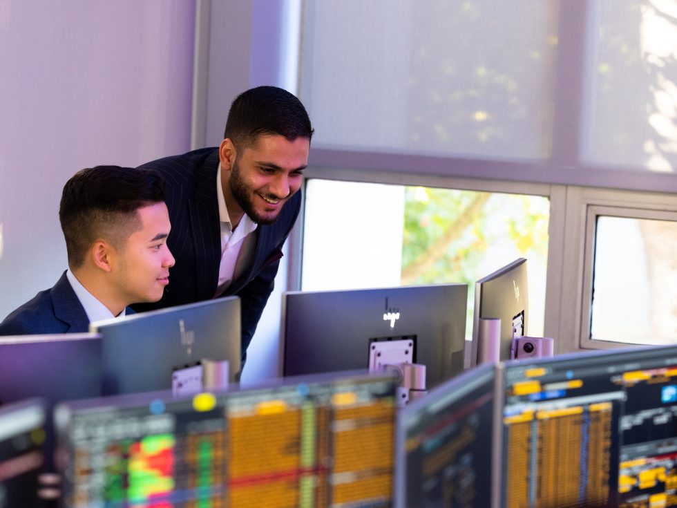 Business students working in the Trading Room on Bloomberg terminals