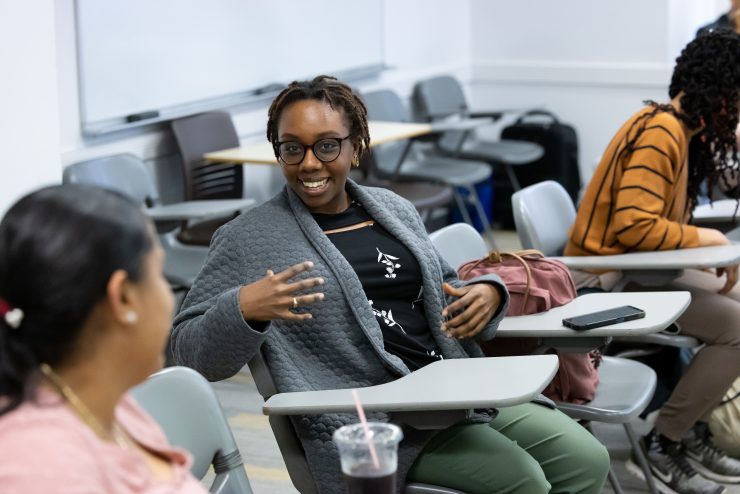 Adelphi social work classroom full of students smiling and talking.