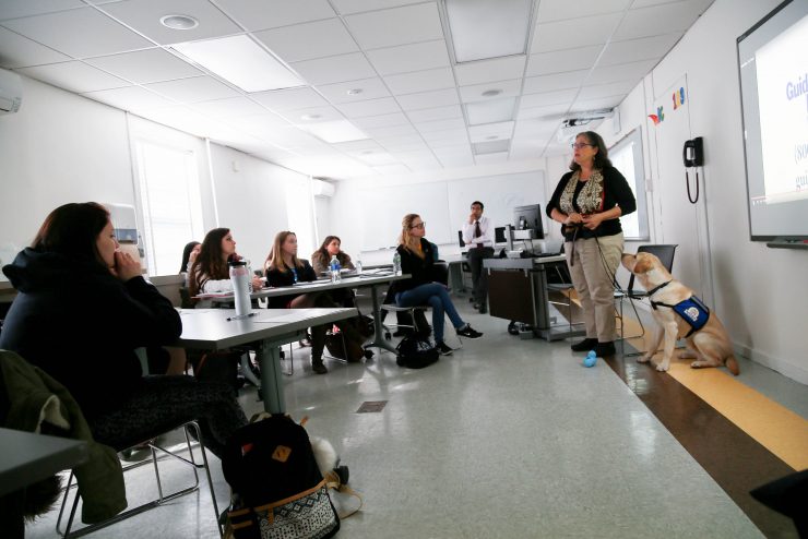 Professor Daryl Gordon with the Gadget the Guide Dog Puppy in class.