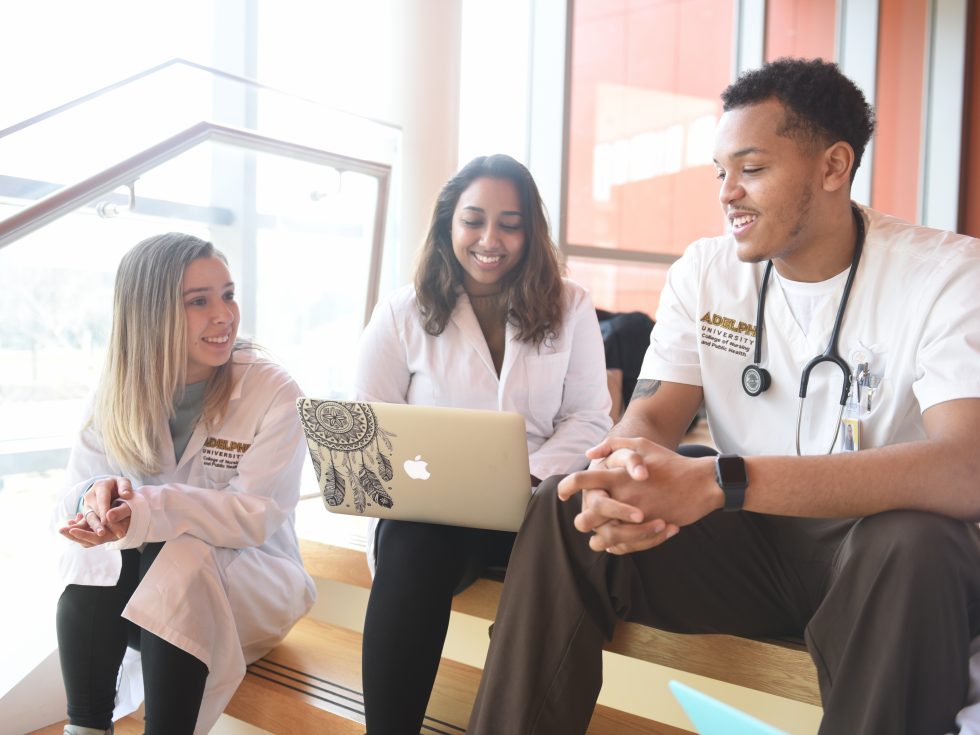 Three nursing students talking on the steps on the Nexus Building at Adelphi University