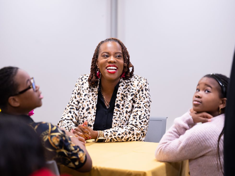 Adelphi student smiles with her children at an Adelphi CPCS event celebrating mothers