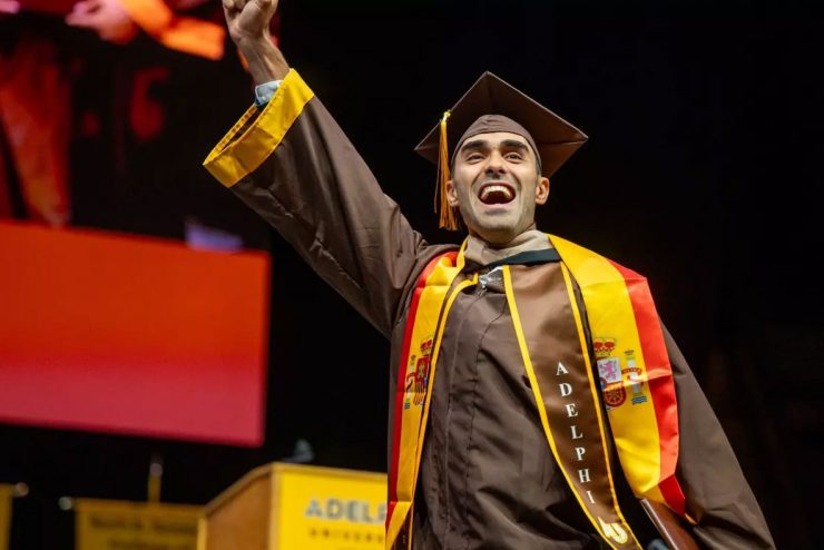 Adelphi graduate wearing honor and leadership society cords.