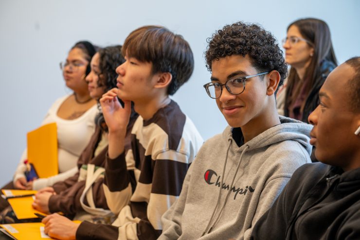 Adelphi student smiling and looking at the camera from a crowd