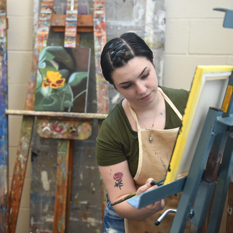Adelphi art student painting in the studio