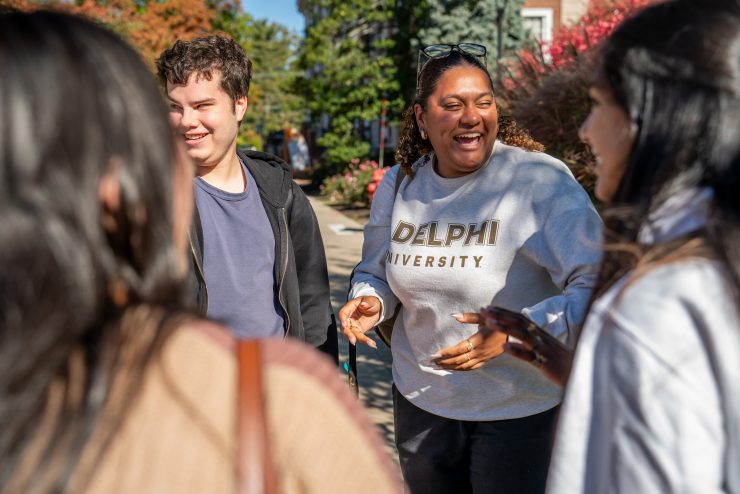 An Adelphi student laughs with friends on campus.