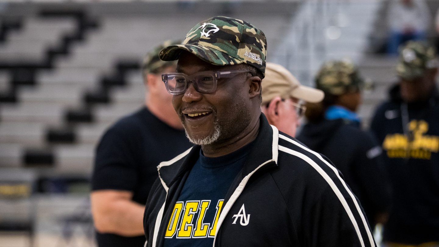 Adelphi alumni wearing a camouflage hat with the Adelphi Panther logo