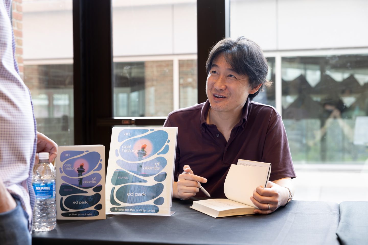 Novelist Ed Park, who appeared in the panel discussion on the art of time in fiction, signs a copy of his book of short stories, An Oral History of Atlantis, for a festivalgoer.