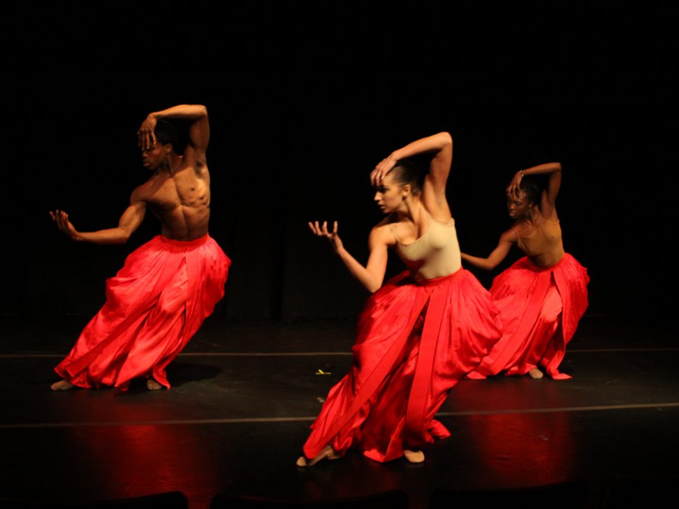 Adelphi University dance performance of Kylian 2. Three dancers wearing flowing red costumes.