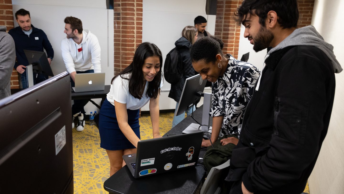 Research conference - students looking at computer data together