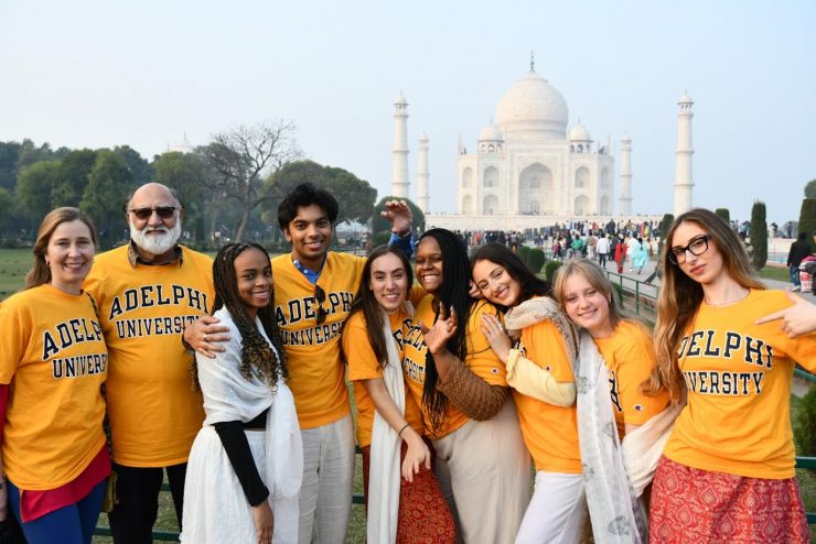 Adelphi University students and faculty post in front of the Taj Mahal wearing Adelphi shirts.