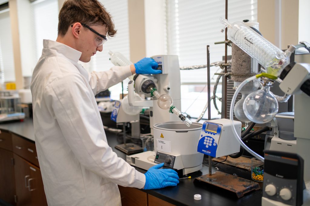 Adelphi chemistry student working with lab equipment