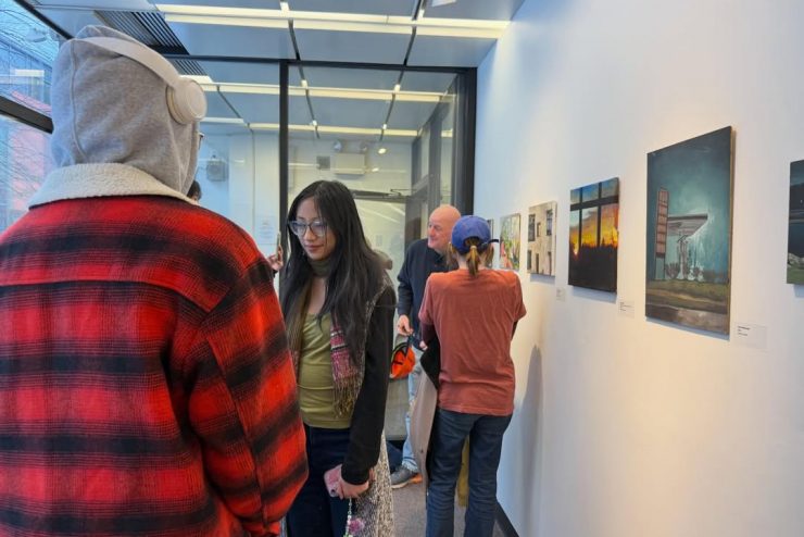 Adelphi art gallery exhibit with students walking through