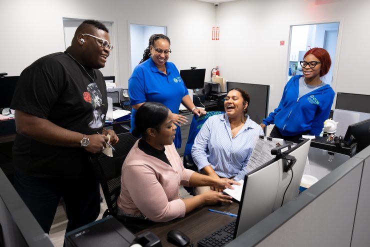 Adelphi university Jaggar Community Fellow at their internship laughing with staff.