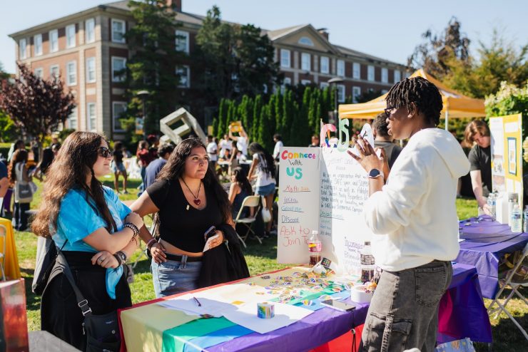 Adelphi club fair on campus. Student clubs host tables to recruit members.