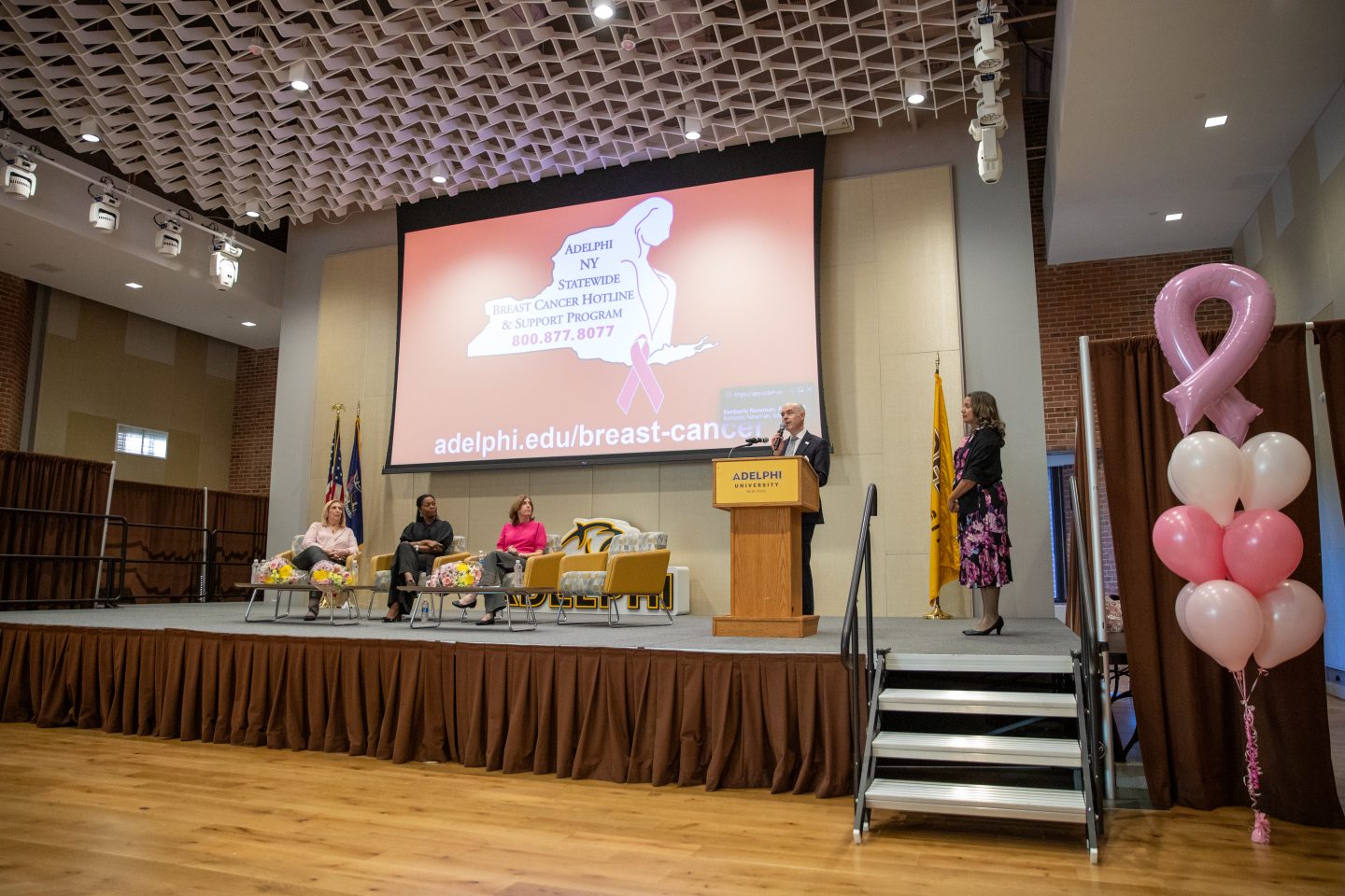 Wide photo of stage with five people