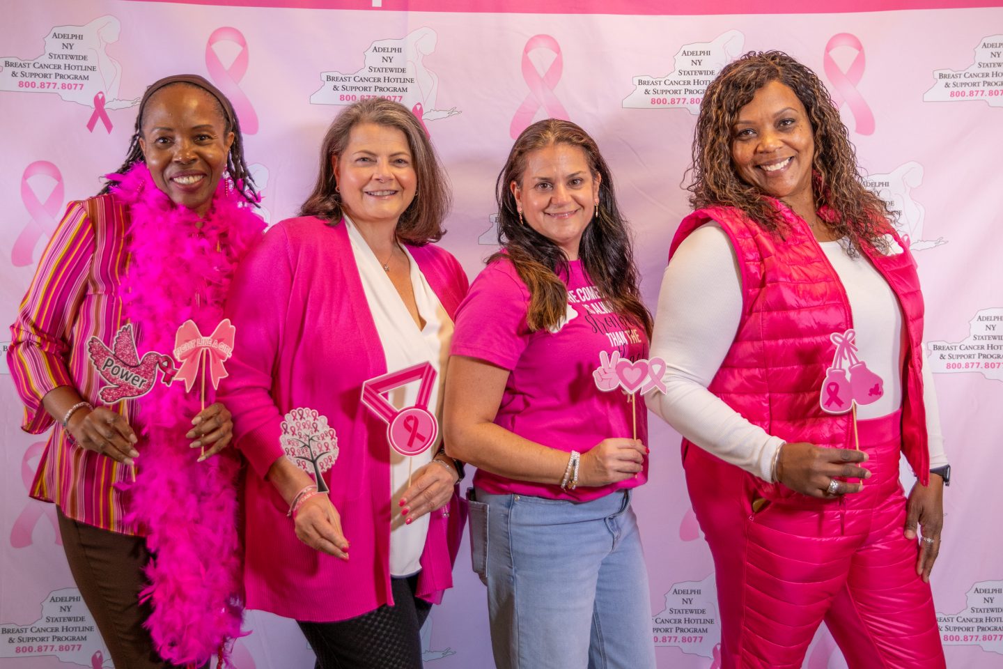Four women in pink with photo props
