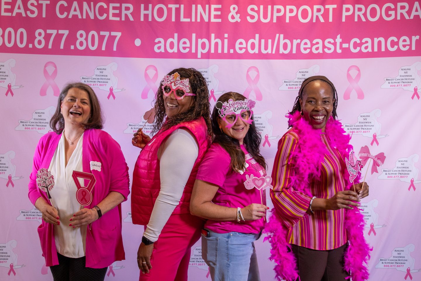 Four women in pink with photo props
