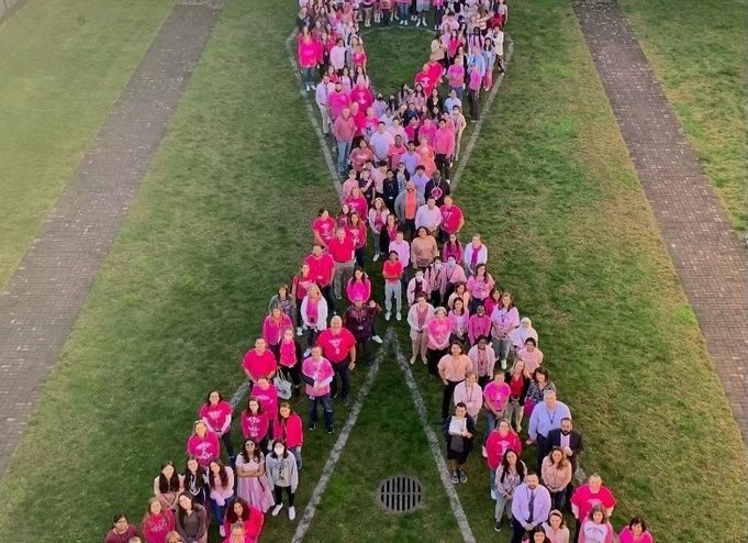 People from New Hyde Park Memorial High School forming a human pink ribbon.