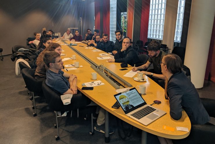 Adelphi students studying in Finland around a board room table.