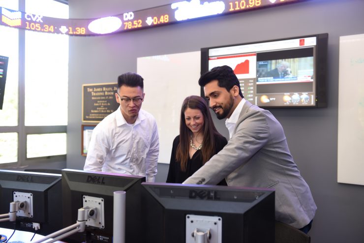 Adelphi students working together in the James Riley Jr. Trading Room