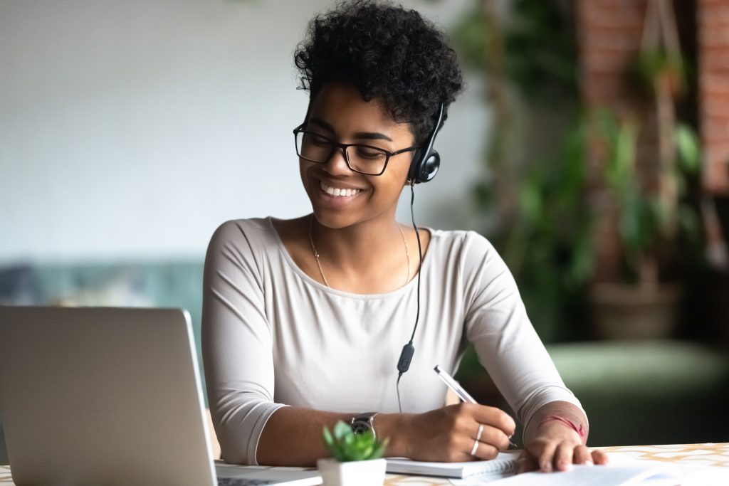 Woman smiling while working on her laptop.