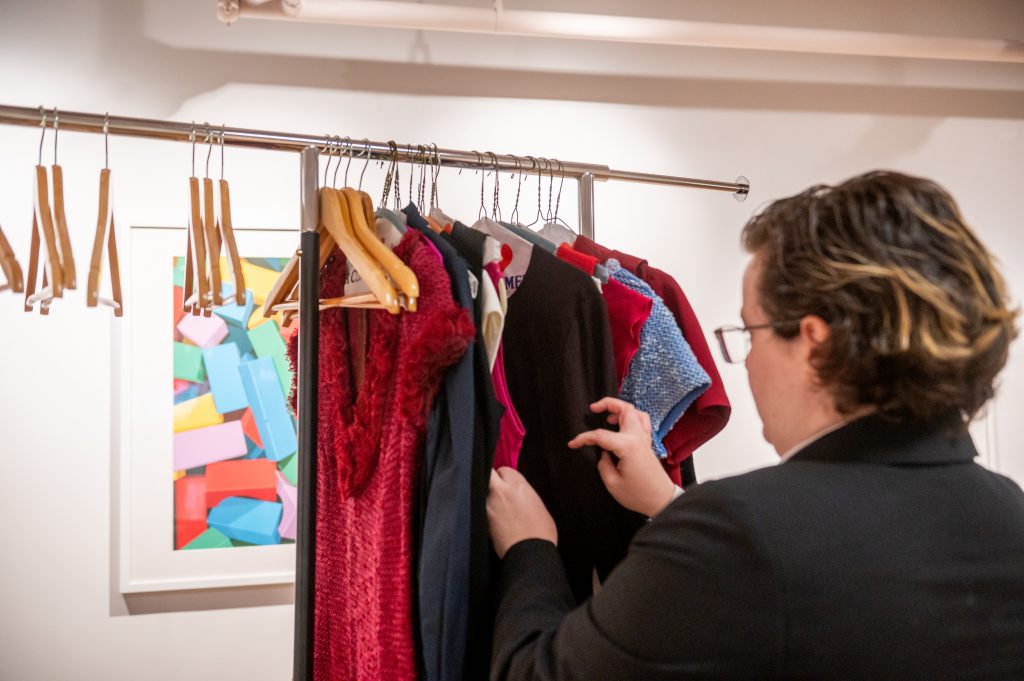 Adelphi University Career Closet: student looks through hangers of donated professional attire.