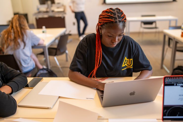 Adelphi student typing on a laptop