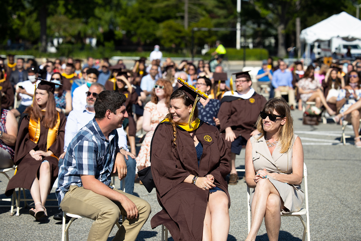 An Adelphi graduate seated with their family members. For social distancing all graduates were seated with two guests in groups of three.