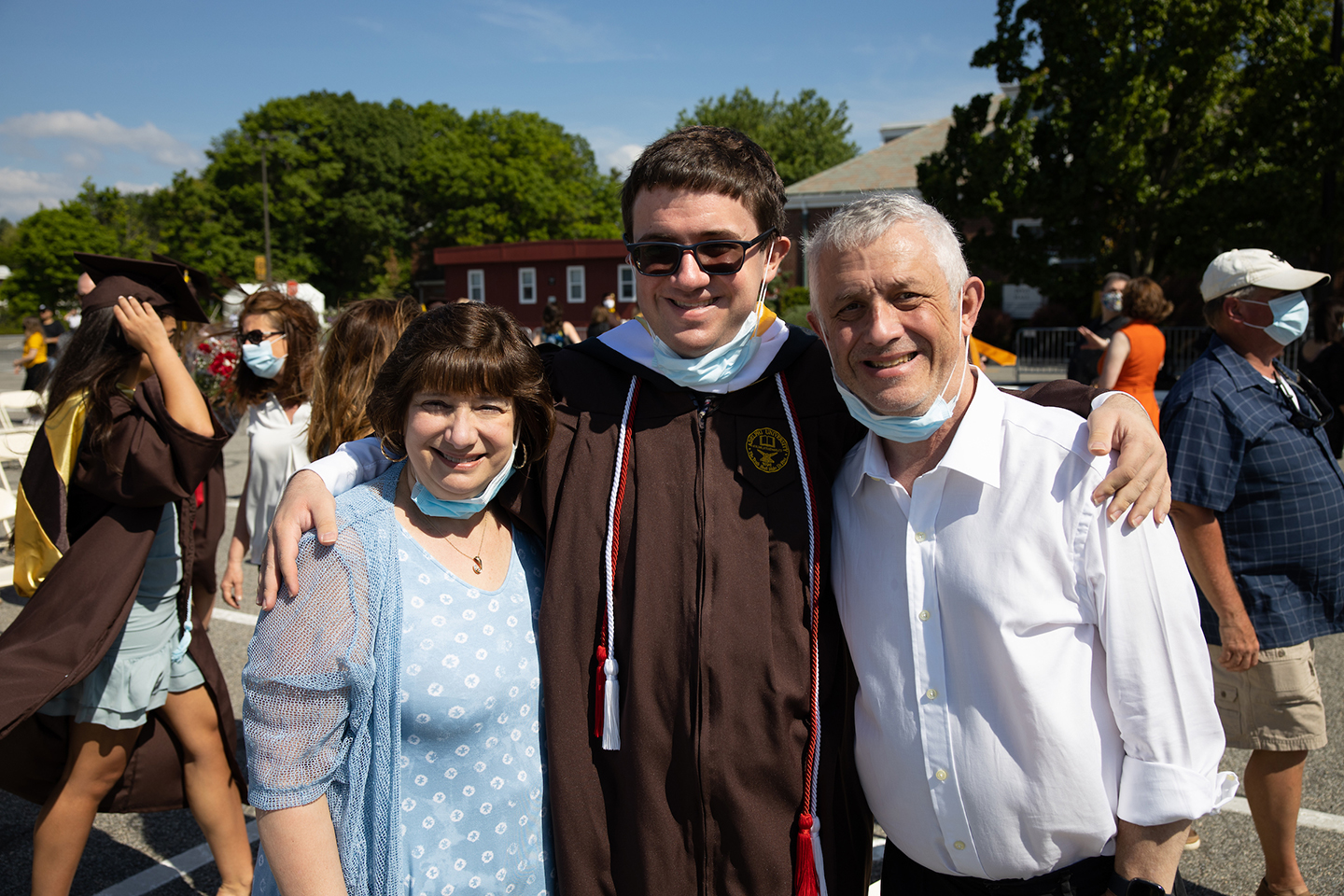 Graduate poses with parents for picture.