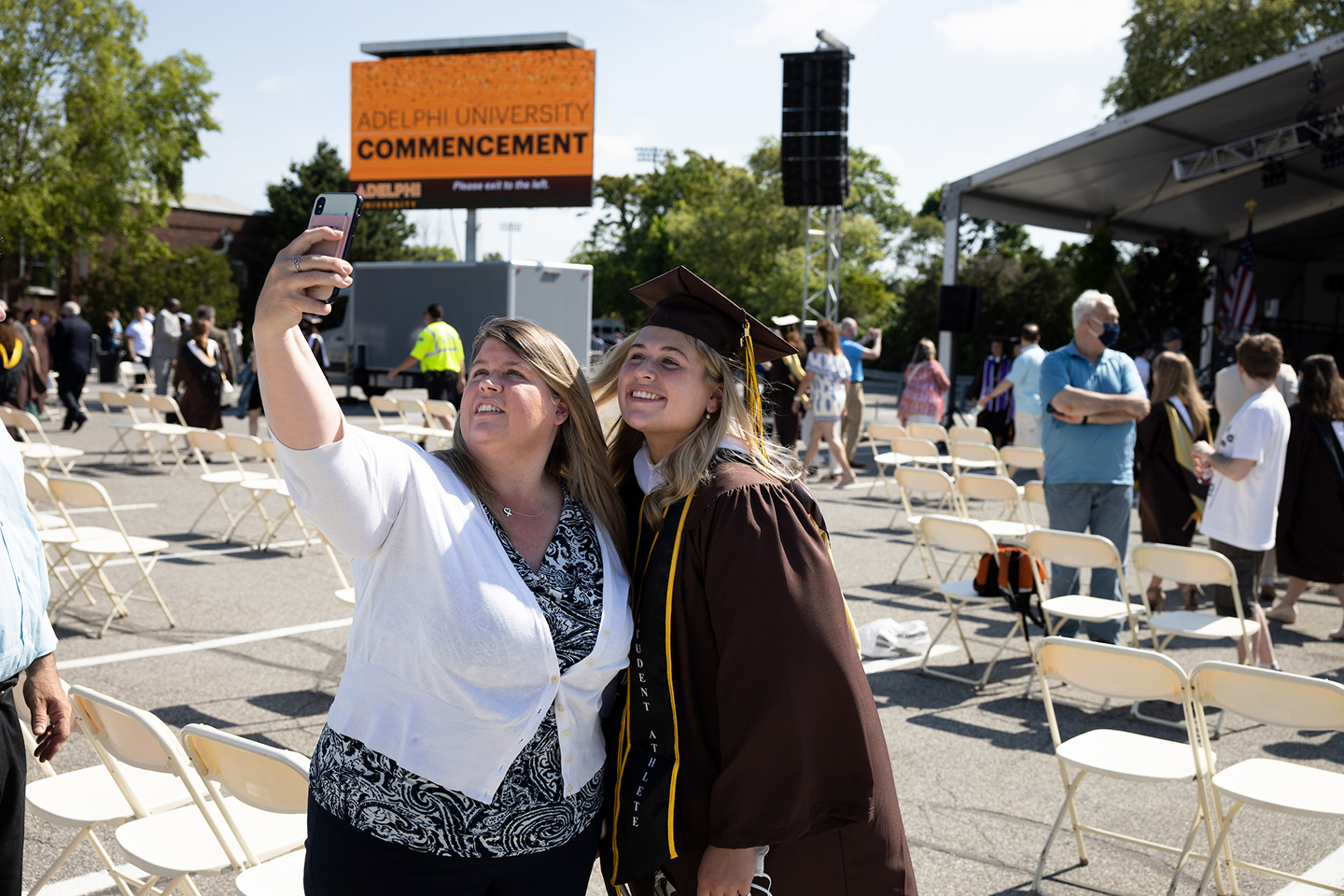 Graduate poses for picture with mother for a selfie at in-person commencement.