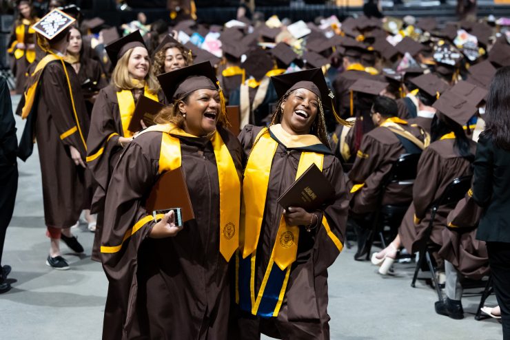 two graduates are joyful at commencement