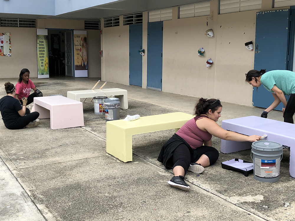 Adelphi students painting outdoor space at a local school.