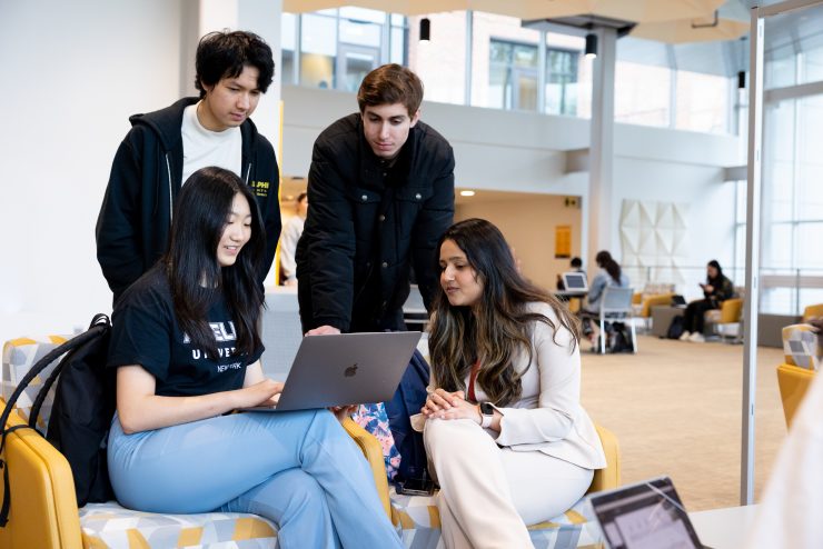 Adelphi International students working on a laptop in the Nexus Lobby