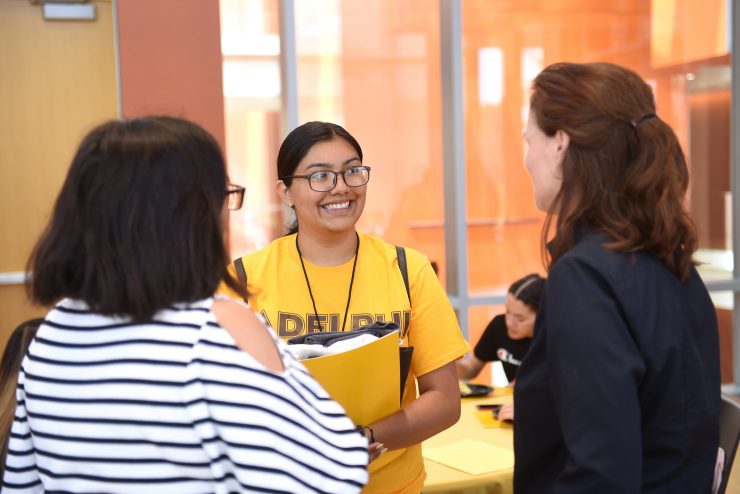 President Riordan speaks with a first-generation student and professor