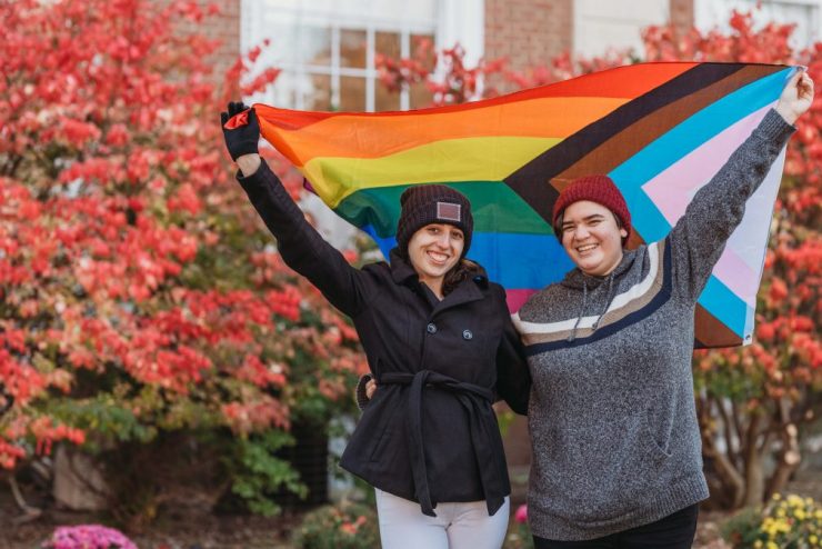 Two students holding LGBTQIA+ flag