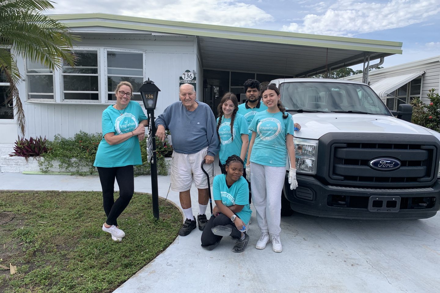 Karen Harkins (from Health Services, and the chaperone of the trip), Harold, Linda Titone, Vishal Gandham, Zakhro Kakhramonova, and Lyn Abby Bigord take a photo outside of Harold's home. The students spent the week repairing his home that was damaged from various hurricanes in Fort Myers, FL.