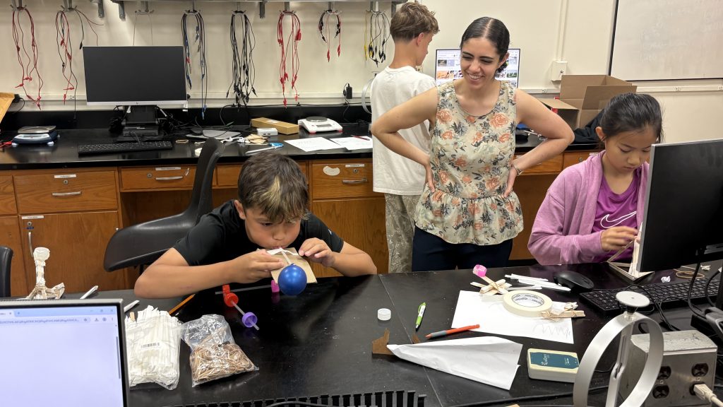 Children in the Adelphi STEM summer camp program. Experimenting with balloons int he lab.