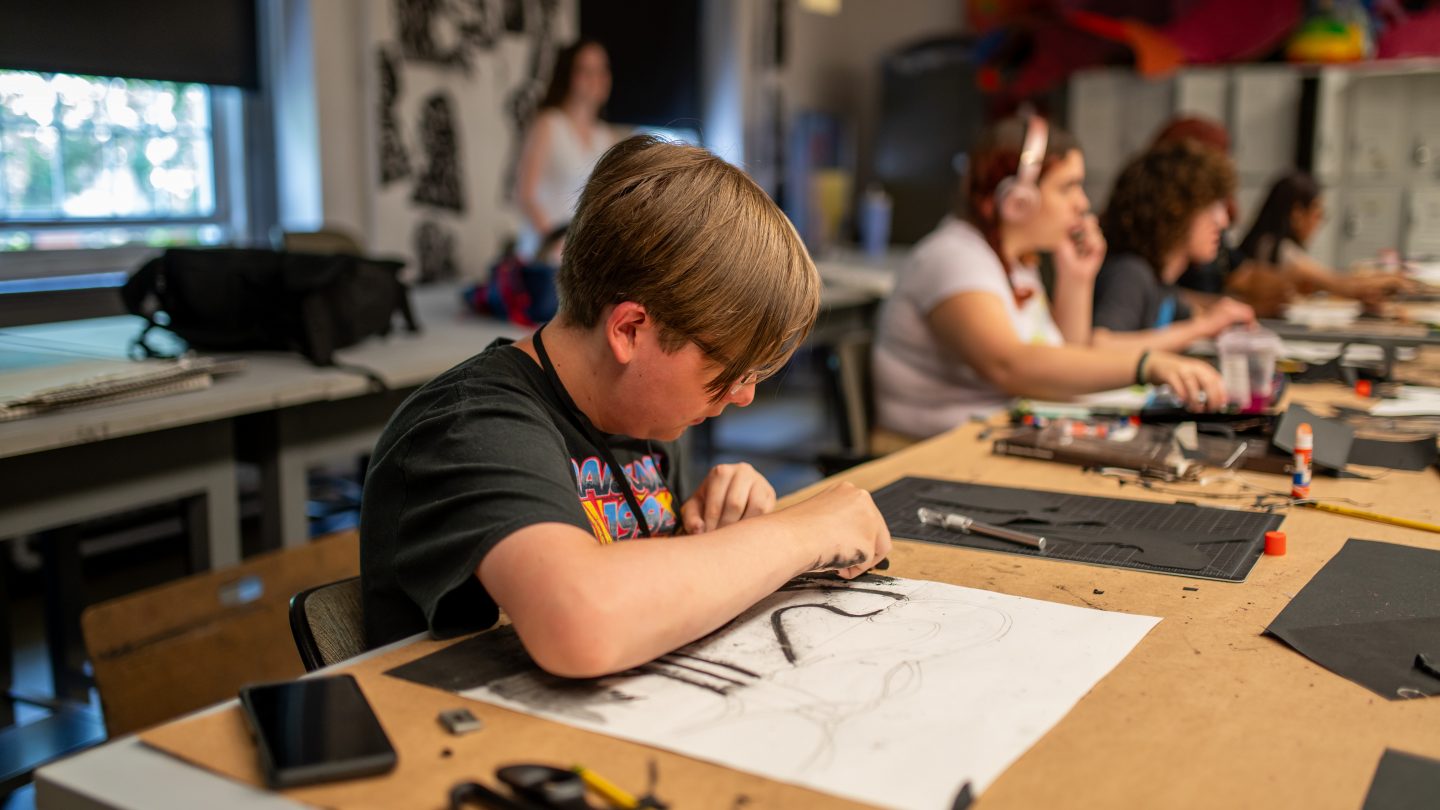 A kid at Adelphi University works in the art studio.