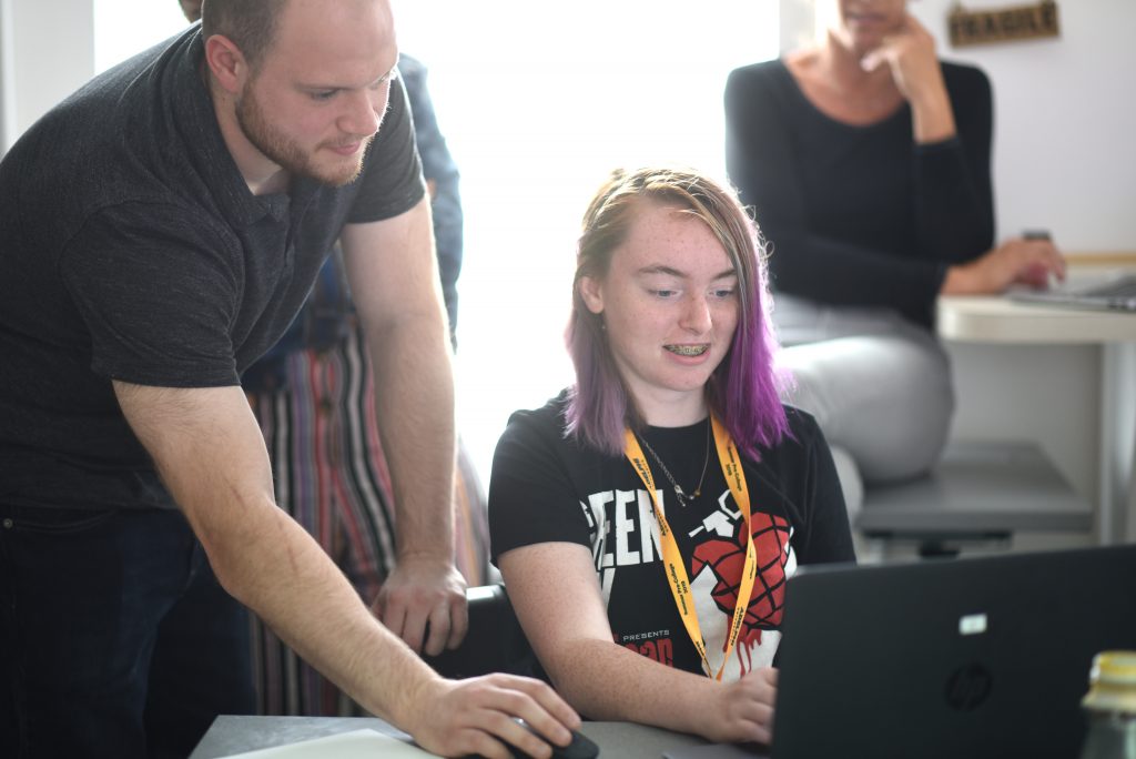 An Adeplphi instructor working with a young camper on a story.