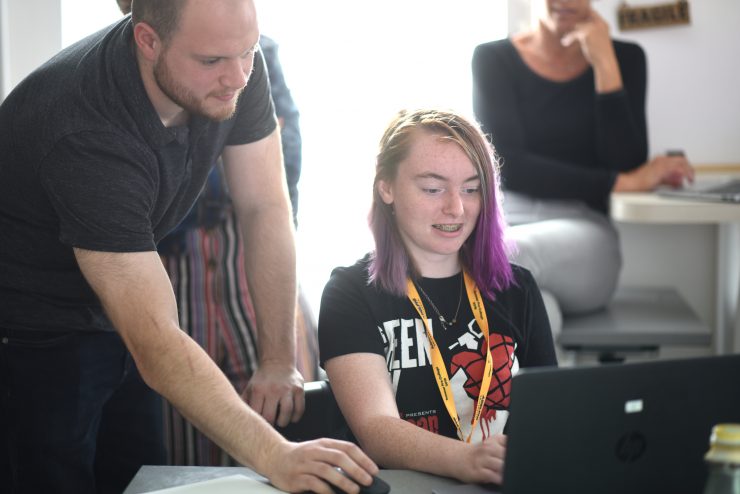 An Adeplphi instructor working with a young camper on a story.