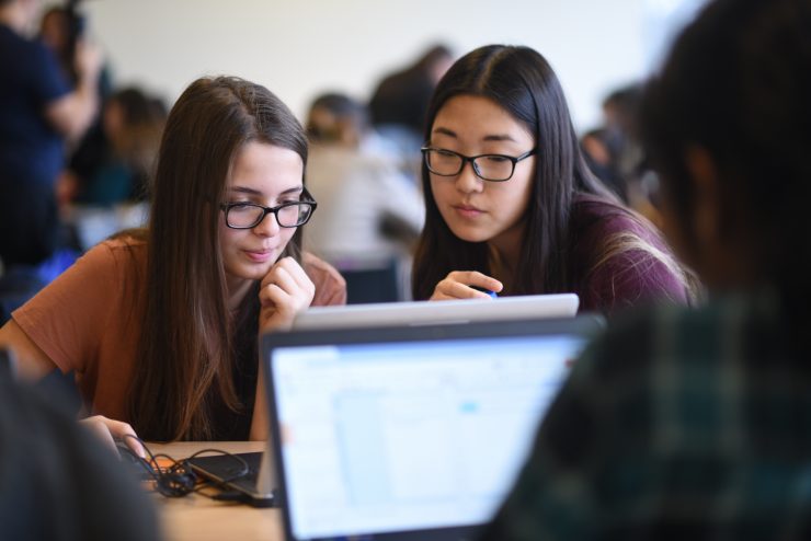 Two students working on a laptop.