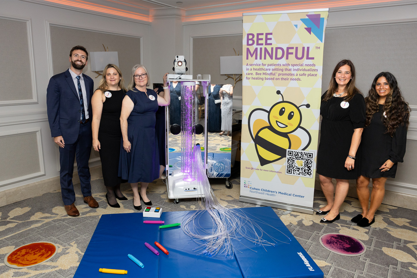 Standing before a display of sensory toys, representatives from Cohen Children’s Medical Center share the Bee Mindful program.
